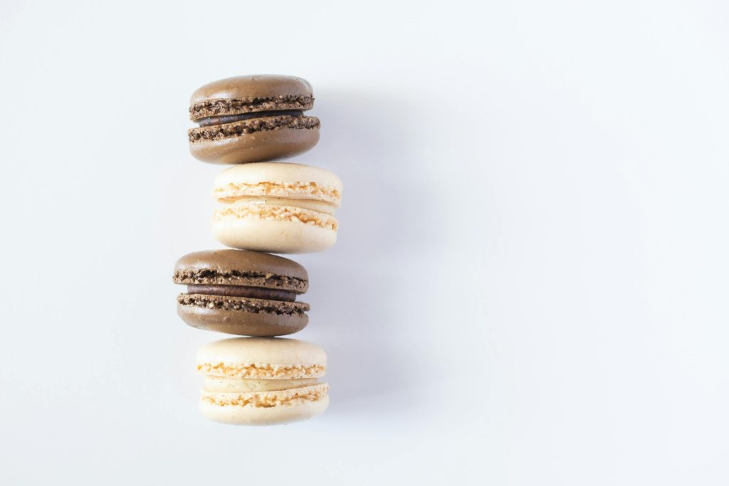 A visually pleasing arrangement of French macarons showcasing rich colors and textures on a minimalist white surface.